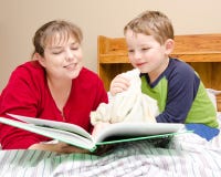 Mother reads bedtime story to young boy stock photo Mother reads bedtime story to young boy stock photo