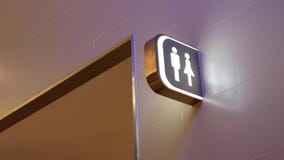 Motion of man and woman washroom logo on wall stock video Motion of man and woman washroom logo on wall stock video