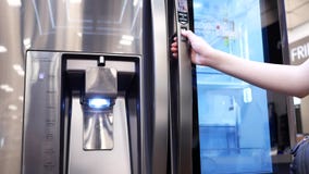 Motion of people trying a new fridge inside electronic store