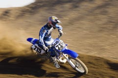 Moto d'équitation de coureur de motocross sur la cendrée images stock Moto d'équitation de coureur de motocross sur la cendrée images stock