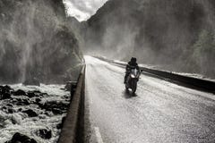 Motorbike Driving Fast On Wet Canyon Valley Road And Bridge Across River. Stock Images Motorbike Driving Fast On Wet Canyon Valley Road And Bridge Across River. Stock Images