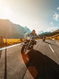 Motorcycle driver riding japanese high power cruiser in Alpine highway on famous Hochalpenstrasse, Austria. Royalty Free Stock Images Motorcycle driver riding japanese high power cruiser in Alpine highway on famous Hochalpenstrasse, Austria. Royalty Free Stock Images