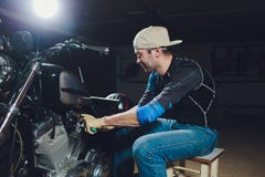 Motorcycle mechanic repairing engine under supervisors guidance. video camera, laptop to view the inside of the engine royalty free stock image Motorcycle mechanic repairing engine under supervisors guidance. video camera, laptop to view the inside of the engine royalty free stock image