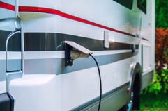 Motorhome stillife. Concept of power supply of the camper. Plug of the electric wire is inserted into the socket of the rv trailer royalty free stock image Motorhome stillife. Concept of power supply of the camper. Plug of the electric wire is inserted into the socket of the rv trailer royalty free stock image