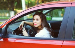 Motorista bonito novo da mulher atrás do carro do vermelho da roda fotografia de stock royalty free Motorista bonito novo da mulher atrás do carro do vermelho da roda fotografia de stock royalty free