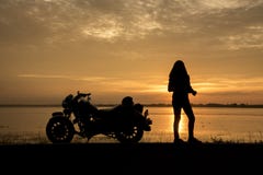 Motorista hermoso de la mujer que disfruta de la puesta del sol, motocicleta femenina del montar a caballo conductor de la moto q foto de archivo libre de regalías Motorista hermoso de la mujer que disfruta de la puesta del sol, motocicleta femenina del montar a caballo conductor de la moto q foto de archivo libre de regalías