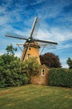 Moulin à vent en bois, buissons feuillus et pelouse verte sous le ciel bleu ensoleillé chez Weesp Photographie stock libre de droits Moulin à vent en bois, buissons feuillus et pelouse verte sous le ciel bleu ensoleillé chez Weesp Photographie stock libre de droits