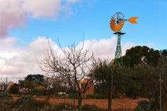Moulin à vent jaune avec la palette de conte sous le temps nuageux et venteux Images stock Moulin à vent jaune avec la palette de conte sous le temps nuageux et venteux Images stock