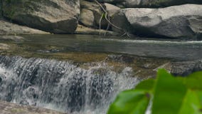 Mountain river from waterfall flowing on large stones in tropical forest. Flow mountain river in waterfall cascade.