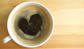 Mousse chaude de café noir de forme de coeur, vue supérieure avec l'espace libre sur la table en bois pour la conception Images stock Mousse chaude de café noir de forme de coeur, vue supérieure avec l'espace libre sur la table en bois pour la conception Images stock