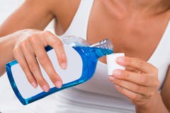 Mouthwash женщины лить в крышку бутылки стоковые фото Mouthwash женщины лить в крышку бутылки стоковые фото