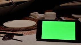 Mouvement de téléphone d'écran vert avec des personnes de tache floue regardant le menu banque de vidéos Mouvement de téléphone d'écran vert avec des personnes de tache floue regardant le menu banque de vidéos