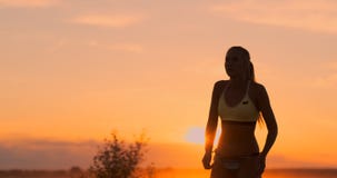 MOVIMENTO LENTO, BAIXO ÂNGULO, FIM ACIMA, ALARGAMENTO DO SOL: Menina atlética que joga saltos do voleibol de praia no ar e nas gr video estoque MOVIMENTO LENTO, BAIXO ÂNGULO, FIM ACIMA, ALARGAMENTO DO SOL: Menina atlética que joga saltos do voleibol de praia no ar e nas gr video estoque