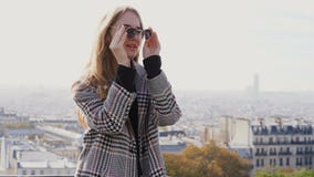 Movimento lento del turista femminile europeo felice in occhiali da sole che sorride alla macchina fotografica stock footage Movimento lento del turista femminile europeo felice in occhiali da sole che sorride alla macchina fotografica stock footage