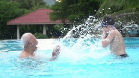 Movimento lento della famiglia asiatica felice che gioca nello stagno Movimento lento della famiglia asiatica felice che gioca nello stagno