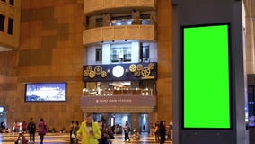 Movimiento de la gente busying a tomar el tren en la noche con el tablero verde del tráfico de la pantalla metrajes Movimiento de la gente busying a tomar el tren en la noche con el tablero verde del tráfico de la pantalla metrajes