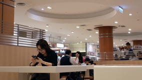 Movimiento de la gente que come las comidas y que juega el teléfono elegante en el área de la zona de restaurantes almacen de metraje de vídeo Movimiento de la gente que come las comidas y que juega el teléfono elegante en el área de la zona de restaurantes almacen de metraje de vídeo