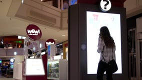 Movimiento de la mujer que comprueba la posición de la tienda delante de la muestra del directorio Movimiento de la mujer que comprueba la posición de la tienda delante de la muestra del directorio