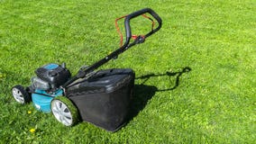 Mowing lawns. Lawn mower on green grass. Mower grass equipment. Mowing gardener care work tool. Close up view. Sunny day. Soft royalty free stock photos Mowing lawns. Lawn mower on green grass. Mower grass equipment. Mowing gardener care work tool. Close up view. Sunny day. Soft royalty free stock photos