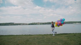 A moça bonita corre com balões à disposição no coustline 4K filme A moça bonita corre com balões à disposição no coustline 4K filme