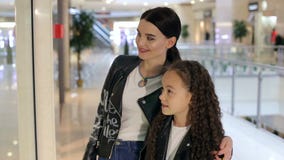 Moça elegante com a irmã mais nova que anda na alameda e na compra vídeos de arquivo Moça elegante com a irmã mais nova que anda na alameda e na compra vídeos de arquivo