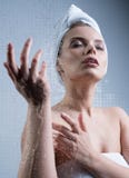 A moça que aprecia a água espirra em sua cara foto de stock royalty free A moça que aprecia a água espirra em sua cara foto de stock royalty free