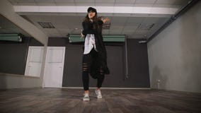 Moça que dança a dança moderna na roupa preta O dançarino faz uns movimentos rápidos e ativos dos braços e dos pés durante ela filme Moça que dança a dança moderna na roupa preta O dançarino faz uns movimentos rápidos e ativos dos braços e dos pés durante ela filme