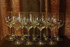 Mucha copa de vino vacía en orden en luz trasera de la tabla y del cobre como imágenes de archivo libres de regalías Mucha copa de vino vacía en orden en luz trasera de la tabla y del cobre como imágenes de archivo libres de regalías