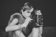 Muchacha accionada Muchachas de la cara de los problemas Mujer con el pelo retro, el maquillaje y la cámara vieja foto de archivo Muchacha accionada Muchachas de la cara de los problemas Mujer con el pelo retro, el maquillaje y la cámara vieja foto de archivo