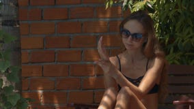 Muchacha agradable en brazos de las manchas de las gafas de sol con la protección solar Muchacha agradable en brazos de las manchas de las gafas de sol con la protección solar