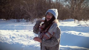 Muchacha alegre que tiene día de invierno soleado de la diversión Ella lanza una bola de nieve en su amigo almacen de video Muchacha alegre que tiene día de invierno soleado de la diversión Ella lanza una bola de nieve en su amigo almacen de video