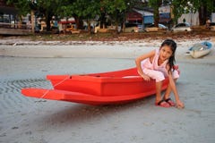 Muchacha asiática que se sienta en el pequeño barco rojo Imagenes de archivo Muchacha asiática que se sienta en el pequeño barco rojo Imagenes de archivo