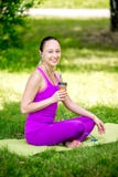 Muchacha atlética que sostiene un smoothie de la fresa foto de archivo Muchacha atlética que sostiene un smoothie de la fresa foto de archivo