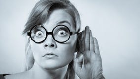Muchacha chocada que escucha detras de las puertas imagenes de archivo Muchacha chocada que escucha detras de las puertas imagenes de archivo