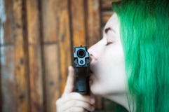 Muchacha con la pistola y el pelo verde fotografía de archivo Muchacha con la pistola y el pelo verde fotografía de archivo