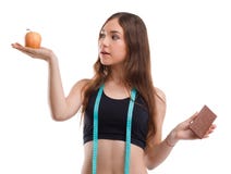 Muchacha de la aptitud que sostiene una manzana mientras que en otra mano sostener el chocolate en un blanco aisló el fondo imágenes de archivo libres de regalías Muchacha de la aptitud que sostiene una manzana mientras que en otra mano sostener el chocolate en un blanco aisló el fondo imágenes de archivo libres de regalías
