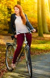 Muchacha de la belleza que se relaja en parque del otoño con la bicicleta, al aire libre fotos de archivo libres de regalías Muchacha de la belleza que se relaja en parque del otoño con la bicicleta, al aire libre fotos de archivo libres de regalías