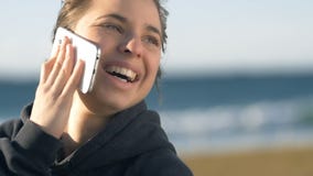 Muchacha de risa que habla en parecer sonriente del teléfono feliz al aire libre almacen de video Muchacha de risa que habla en parecer sonriente del teléfono feliz al aire libre almacen de video