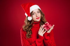 Muchacha en el suéter rojo que lleva a cabo el regalo de Navidad que lleva a Santa Clau Imagen de archivo libre de regalías Muchacha en el suéter rojo que lleva a cabo el regalo de Navidad que lleva a Santa Clau Imagen de archivo libre de regalías
