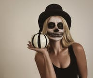 Muchacha esquelética asustadiza de Halloween que sostiene la decoración de la calabaza imagenes de archivo Muchacha esquelética asustadiza de Halloween que sostiene la decoración de la calabaza imagenes de archivo