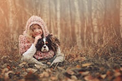 Muchacha feliz del niño con su perro del perro de aguas en paseo caliente acogedor del otoño Fotos de archivo libres de regalías Muchacha feliz del niño con su perro del perro de aguas en paseo caliente acogedor del otoño Fotos de archivo libres de regalías