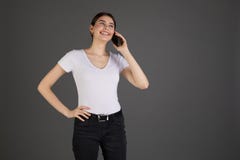 Muchacha hermosa feliz positiva con el pelo moreno en la camiseta blanca imagen de archivo libre de regalías Muchacha hermosa feliz positiva con el pelo moreno en la camiseta blanca imagen de archivo libre de regalías