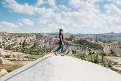 Muchacha hermosa joven del viaje encima de una colina en Cappadocia, Turquía Viaje, éxito, libertad, logro Ella va fotografía de archivo Muchacha hermosa joven del viaje encima de una colina en Cappadocia, Turquía Viaje, éxito, libertad, logro Ella va fotografía de archivo