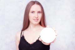 Muchacha hermosa que lleva a cabo el fondo borroso que lleva a cabo el espacio redondo de la copia para una inscripci?n o una pod imagen de archivo libre de regalías Muchacha hermosa que lleva a cabo el fondo borroso que lleva a cabo el espacio redondo de la copia para una inscripci?n o una pod imagen de archivo libre de regalías