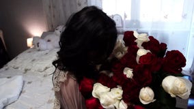 Muchacha hermosa que se sienta con un ramo grande de flores, de alegría y de sonrisa, cámara lenta Muchacha hermosa que se sienta con un ramo grande de flores, de alegría y de sonrisa, cámara lenta