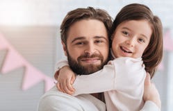 Muchacha linda encantada que abraza a su papá Fotografía de archivo libre de regalías Muchacha linda encantada que abraza a su papá Fotografía de archivo libre de regalías