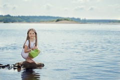 Muchacha linda que se prepara para lanzar el barco de papel en el lago Foto de archivo Muchacha linda que se prepara para lanzar el barco de papel en el lago Foto de archivo