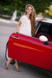 Muchacha morena embarazada y su coche rojo imagen de archivo Muchacha morena embarazada y su coche rojo imagen de archivo
