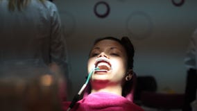Muchacha-paciente con la boca abierta, rasguñando con el finger a través de la cara mientras que ella espera al dentista almacen de metraje de vídeo Muchacha-paciente con la boca abierta, rasguñando con el finger a través de la cara mientras que ella espera al dentista almacen de metraje de vídeo