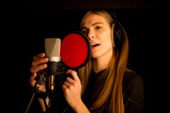 Muchacha que canta al micrófono en estudio Proceso de crear la nueva canción imagenes de archivo Muchacha que canta al micrófono en estudio Proceso de crear la nueva canción imagenes de archivo